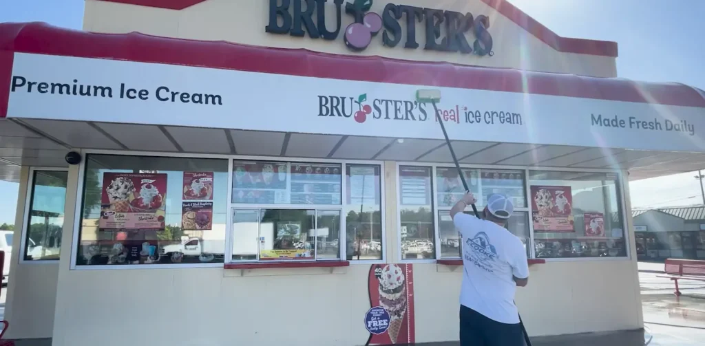 Worker pressure washing the exterior wall of a local storefront in Jacksonville, FL