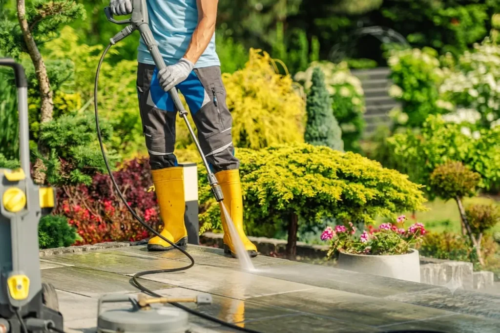 Technician pressure washing a garden walkway and patio in Jacksonville, FL